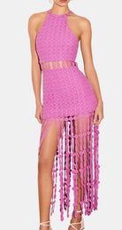 A pink knit midi dress with fringe details, displayed on a mannequin.